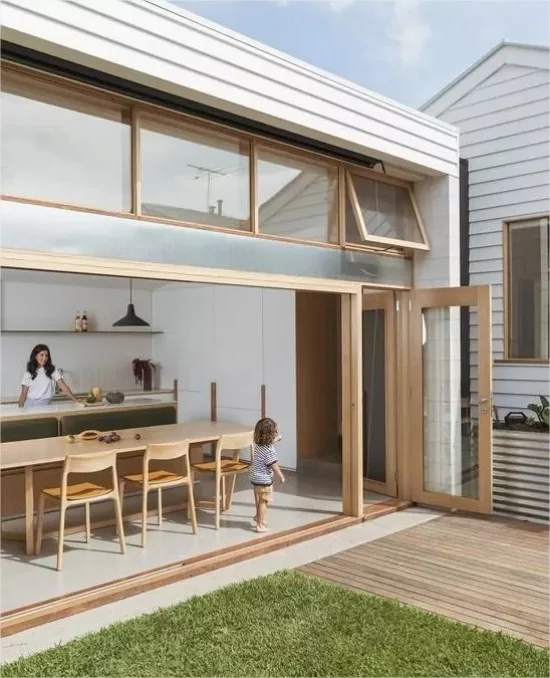 Indoor-Outdoor-Kuechen Mutter Kind moderne Raumgestaltung helles Holz Glaswand