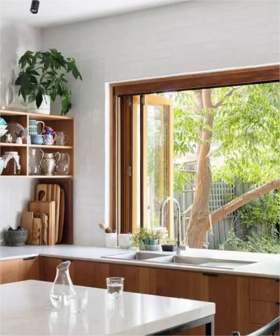 Indoor-Outdoor-Kuechen Spühle Kuecheninsel offense Fenster Blick auf gruene Pflanzen
