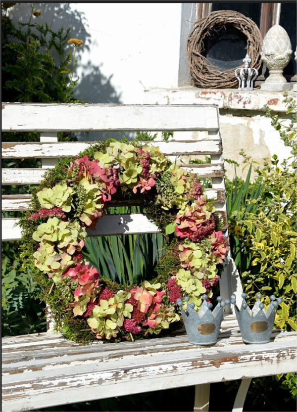 Kranz aus Hortensien auf eine Gartenbank gestellt Deko draußen im Landhausstil