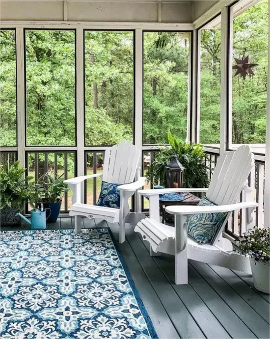 Moderne Glasveranda Weiß Blau Teppich Sofa Kissen viele gruene Topfpflanzen