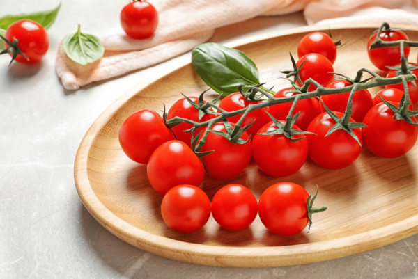 Tomaten richtig lagern kleine reife Tomaten in Holzschuessel auf der Theke aufbewahren