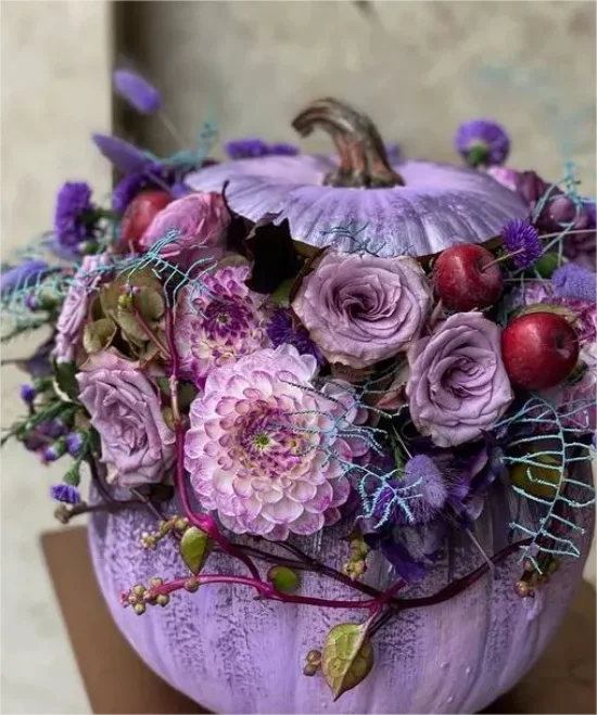 Kuerbisse mit Blumen schmuecken lila Farbschema herrliches Arrangement