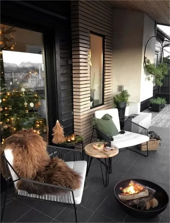 Winterdeko draussen Metallsessel Kunstpelz Feuerstelle Weihnachtsbaum auf der Veranda