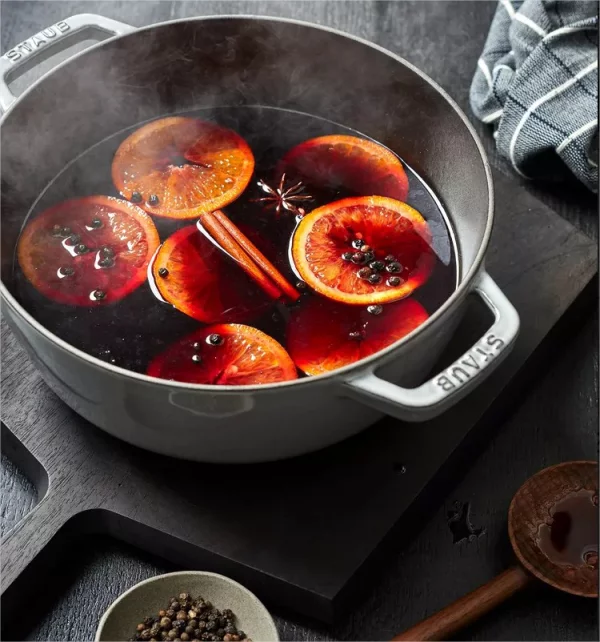 Festliche Cocktails Gluehwein mit fruchtiger Note im Topt Rotwein Scheiben Orange Zimtstangen