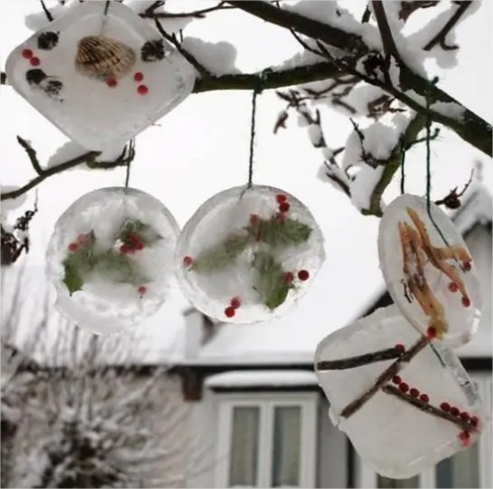 Gefrorene Weihnachtsdeko draussen Anhaenger im Garten weisser Hintergrund