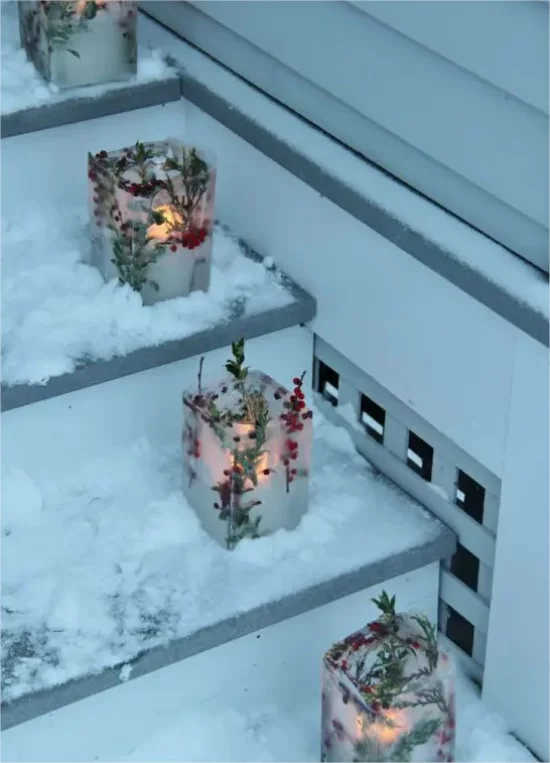 Gefrorene Weihnachtsdeko draussen Windlichter auf der Haustreppe