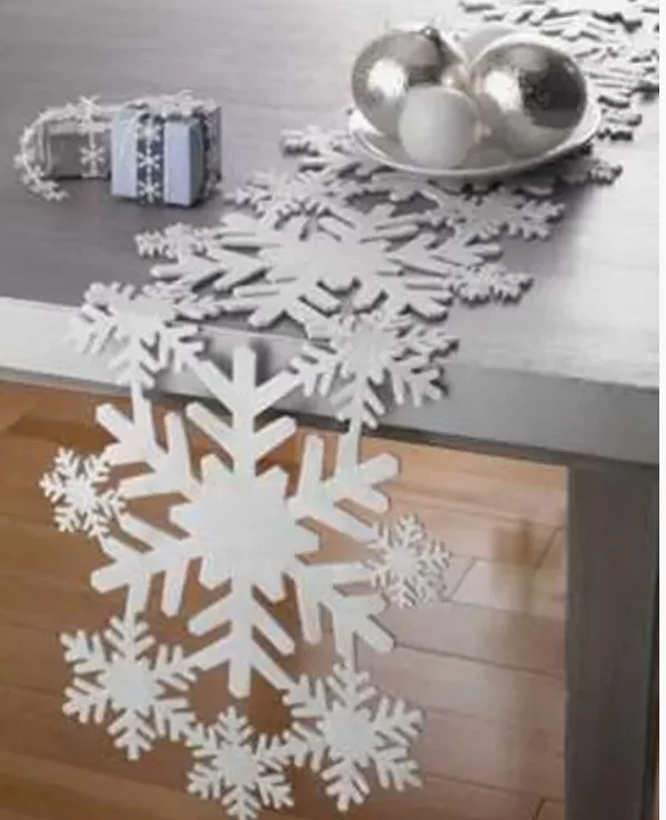 Mit Schneeflocken dekorieren aus Styropor als Tischlaeufer arrangiert