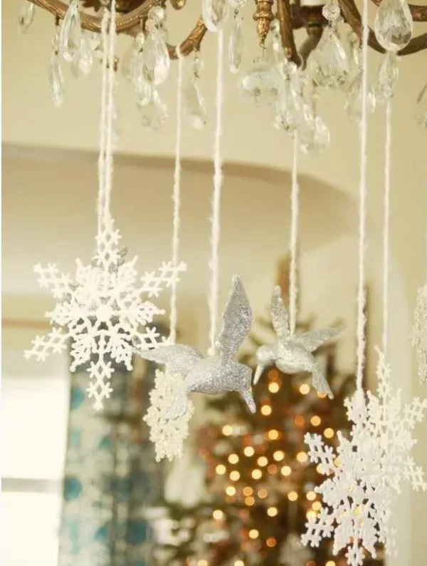 Mit Schneeflocken dekorieren einzelne Schneeflocken hängend am Kronleuchter