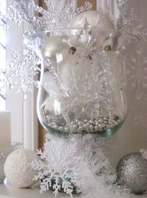 Mit Schneeflocken dekorieren schoenes Weihnachtsarrangement in weiss silber