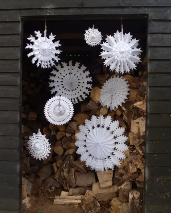 Mit Schneeflocken dekorieren vor der Kaminscheibe weisse Schneeflocken verschiedene Formen