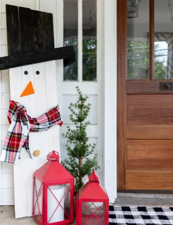 Schneemänner basteln lustige Weihnachtsdeko aus weissen Holzplatten schwarzer Hut Schal rote Laternen