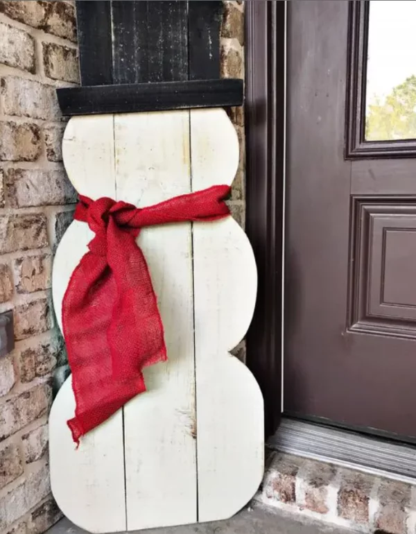 Schneemänner basteln lustige Weihnachtsdeko aus weissen Holzplatten schwarzer Hut roter Schal draussen