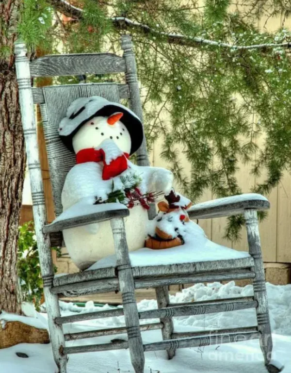 Schneemänner basteln lustige Weihnachtsdeko draussen auf einem Stuhl mit Schnee bedeckt rote Nase Schal Muetze