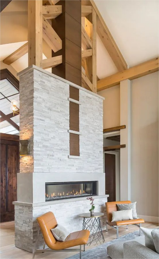 doppelseitige Kamine weisse Trennwand Holzbalken Ledersessel Mix aus zwei Stilen Landhaus und Modern