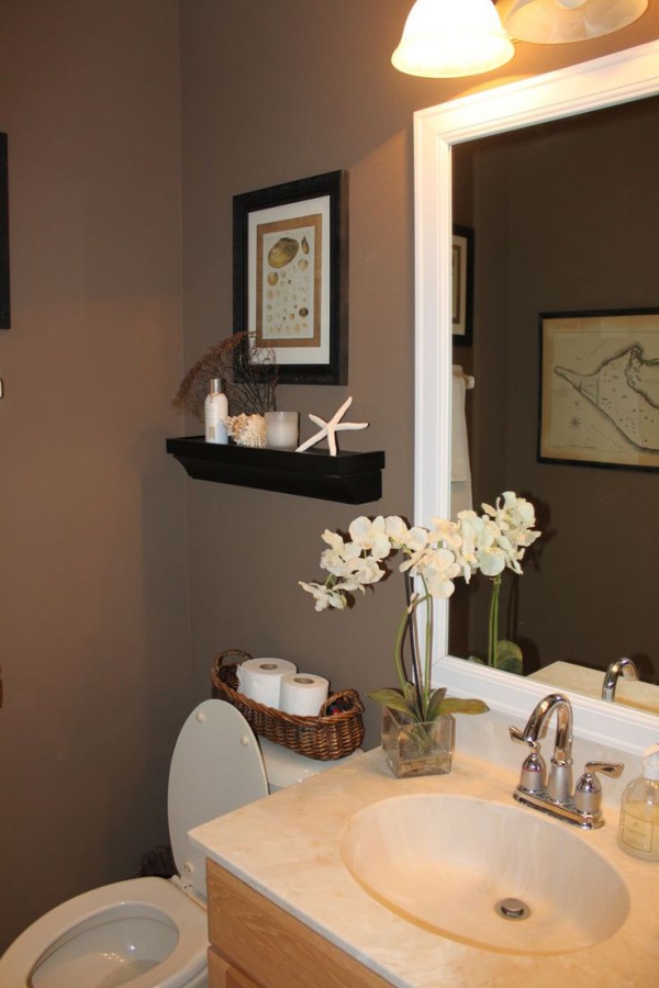 kleines Badezimmer mit braunen Wänden, Orchidee und kleinen Dekoartikeln