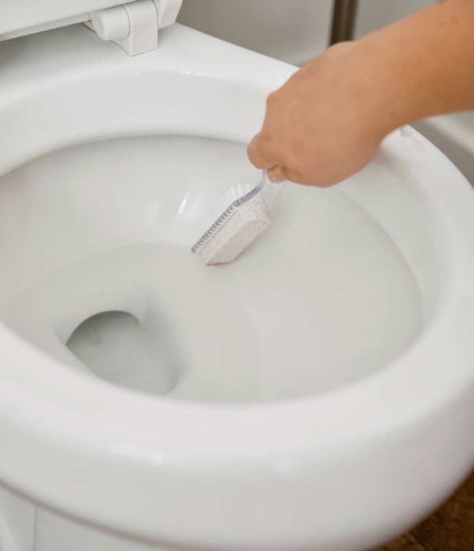 Urinstein entfernen saubere Kloschüssel durch gründliches Schrubben mit Bürste und Stein erreichen