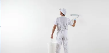 Maler streicht Wand in Weiß