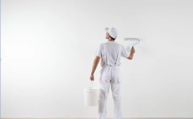 Maler streicht Wand in Weiß