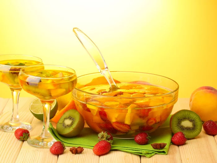 Fruchtbowle mit Erdbeeren, Pfirsichstücken und Kiwi – ein sommerlicher Cocktail