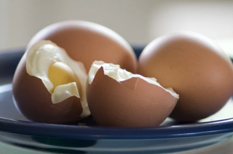 drei gekochte Eier auf einem blauen Teller 