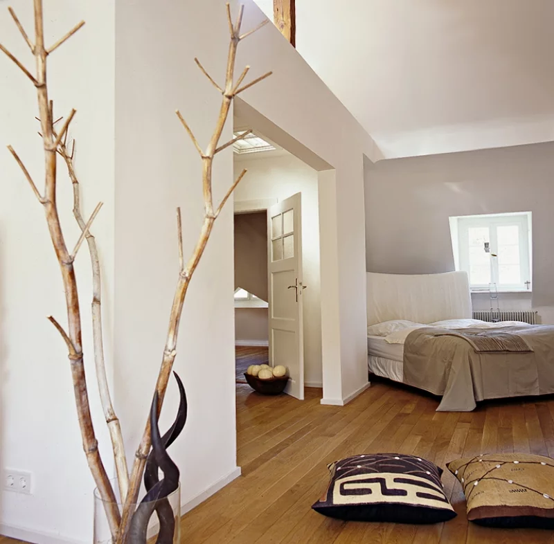 Gemütliches Schlafzimmer mit Schlafbett in der Ecke Wandfarbe heller Lavendel strahlt Ruhe und Ausgelassenheit aus