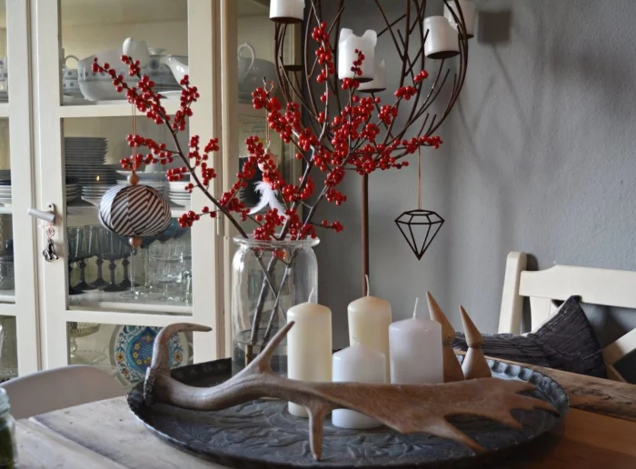 Adventsdeko selber basteln auf einem Tablett Vase mit roten Misteln 4 weiße Kerzen Hirschgeweih
