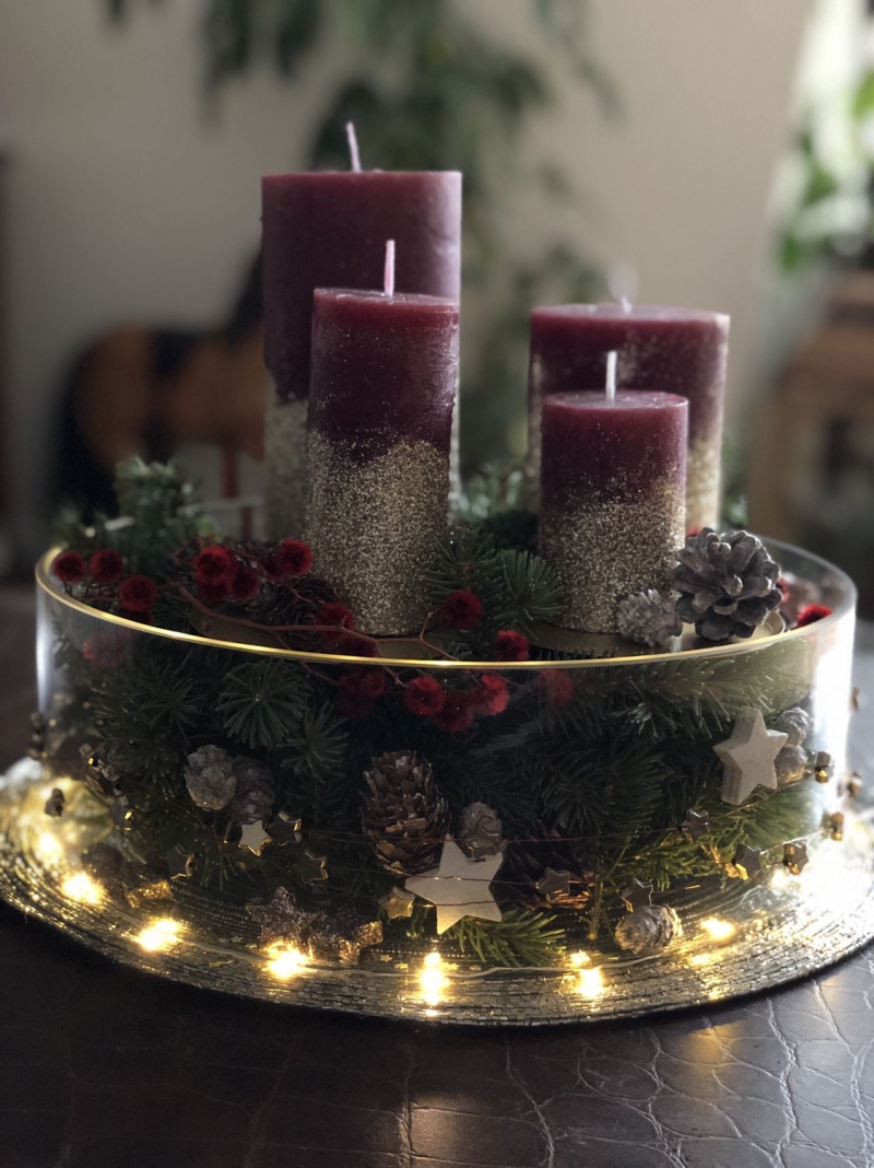 Luxuriöses Weihnachtsgesteck mit vier lila Kerzen
