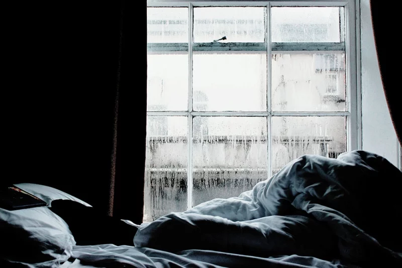 Kondenswasser am Fenster im Schlafzimmer morgens im Winter