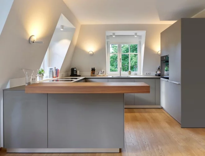 Moderne Küche unter der Dachschräge in Grau und Weiß plus viel Licht