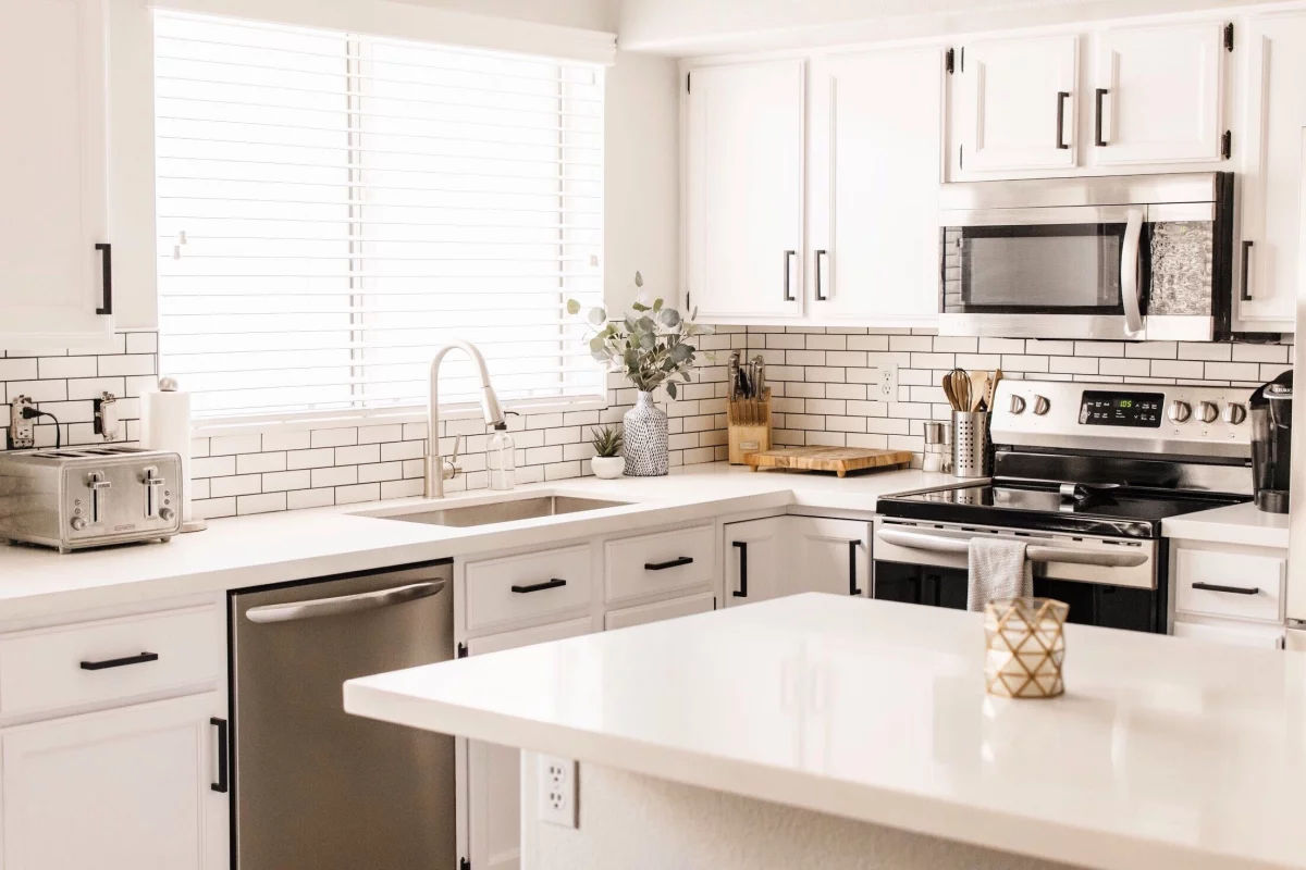 Moderne Küche mit weißen Metro Fliesen und hellen Küchenschränken