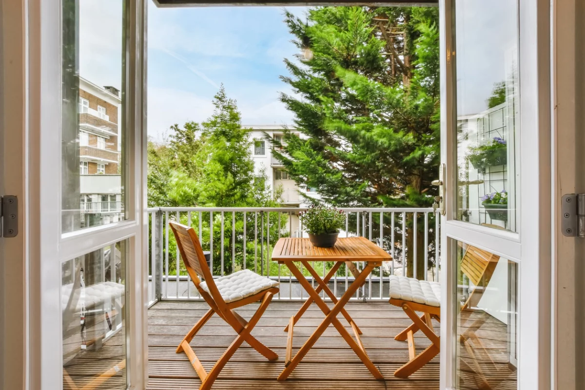 Kleinen Balkon gestalten: ein Holztisch und zwei Klappstühle