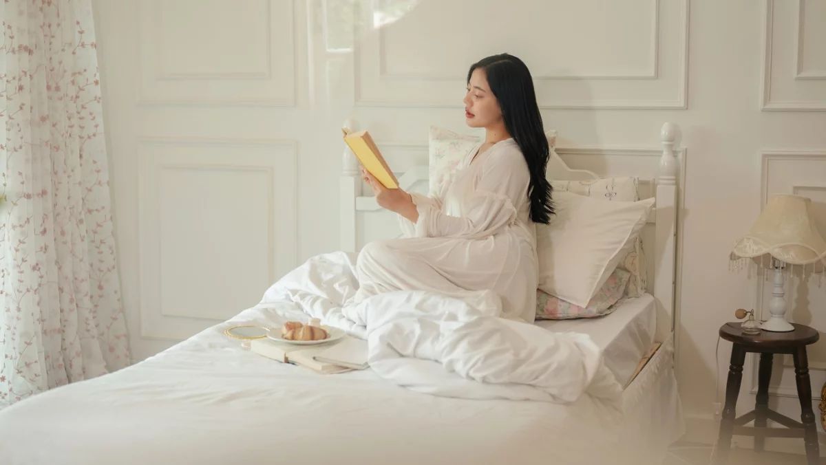 Schlafzimmer einrichten - junge Frau liest im Bett 