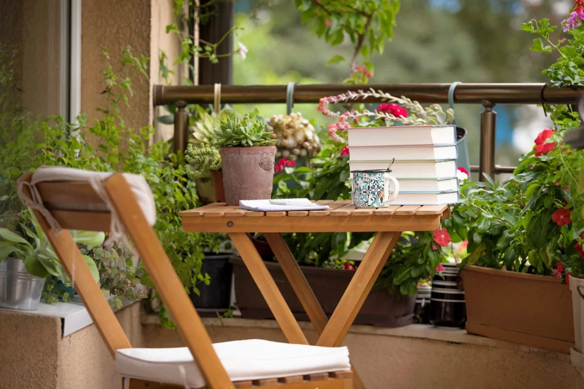 ein Outdoor-Tisch mit Büchern darauf und ein Klappstuhl daneben