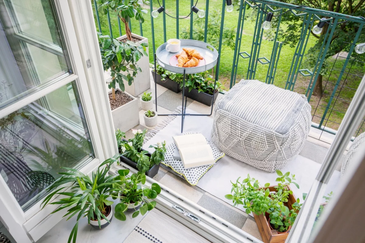 kleinen Balkon mit einfachen Möbeln und grünen Pflanzen gestalten 