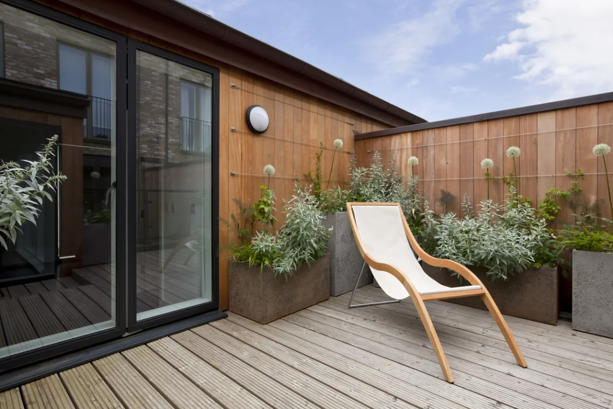 Terrasse gestalten - hohe Holzwand als Sichtschutz