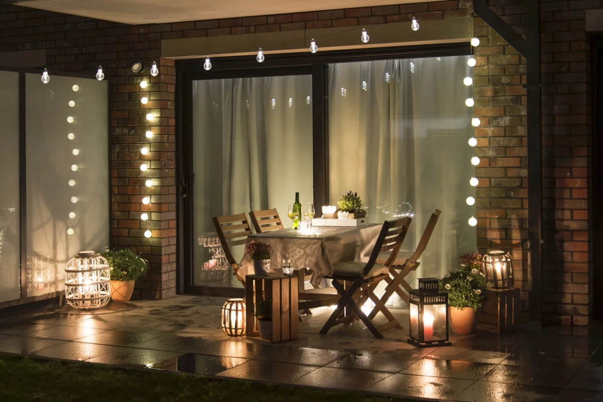 Terrasse gestalten mit schönen Lichterketten und Laternen