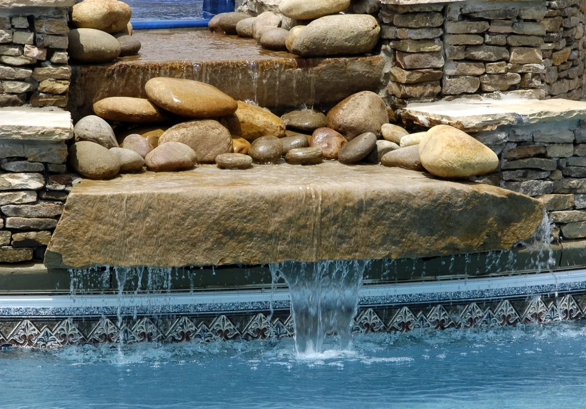 Wasserspiel im Garten aus runden Steinen und großen Steinplatten
