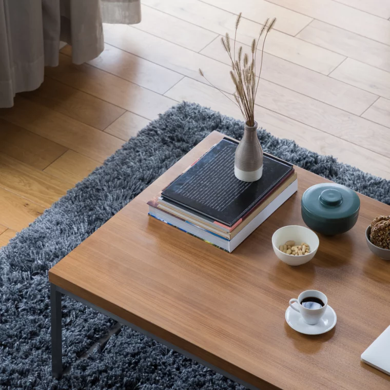 Eine Tasse Kaffee, Vase und Bücher auf dem Couchtisch