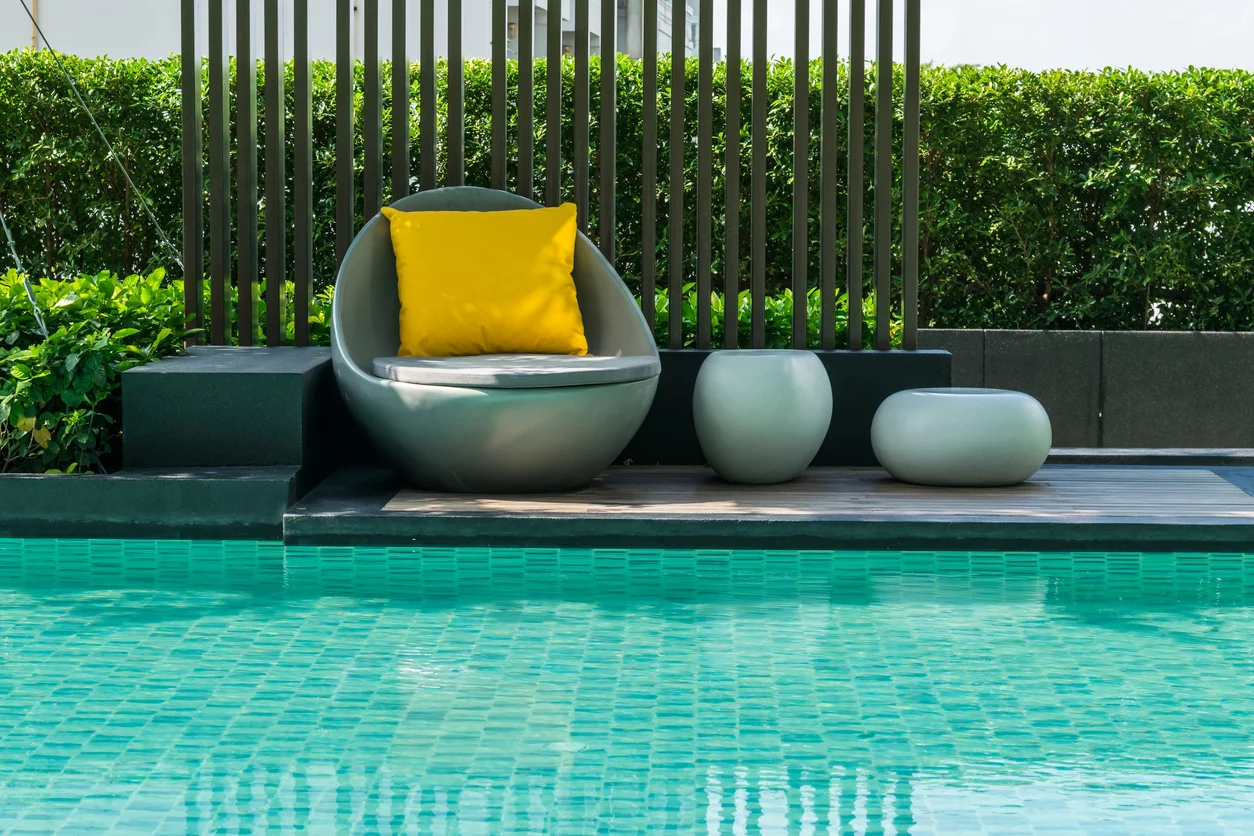 Outdoor-Sessel und zwei Hocker am Pool