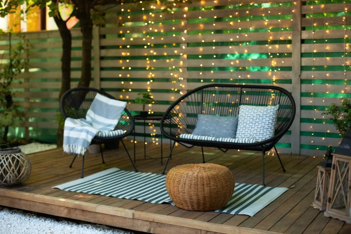 Sitzecke auf einer Holzterrasse mit einfachen Metallmöbeln