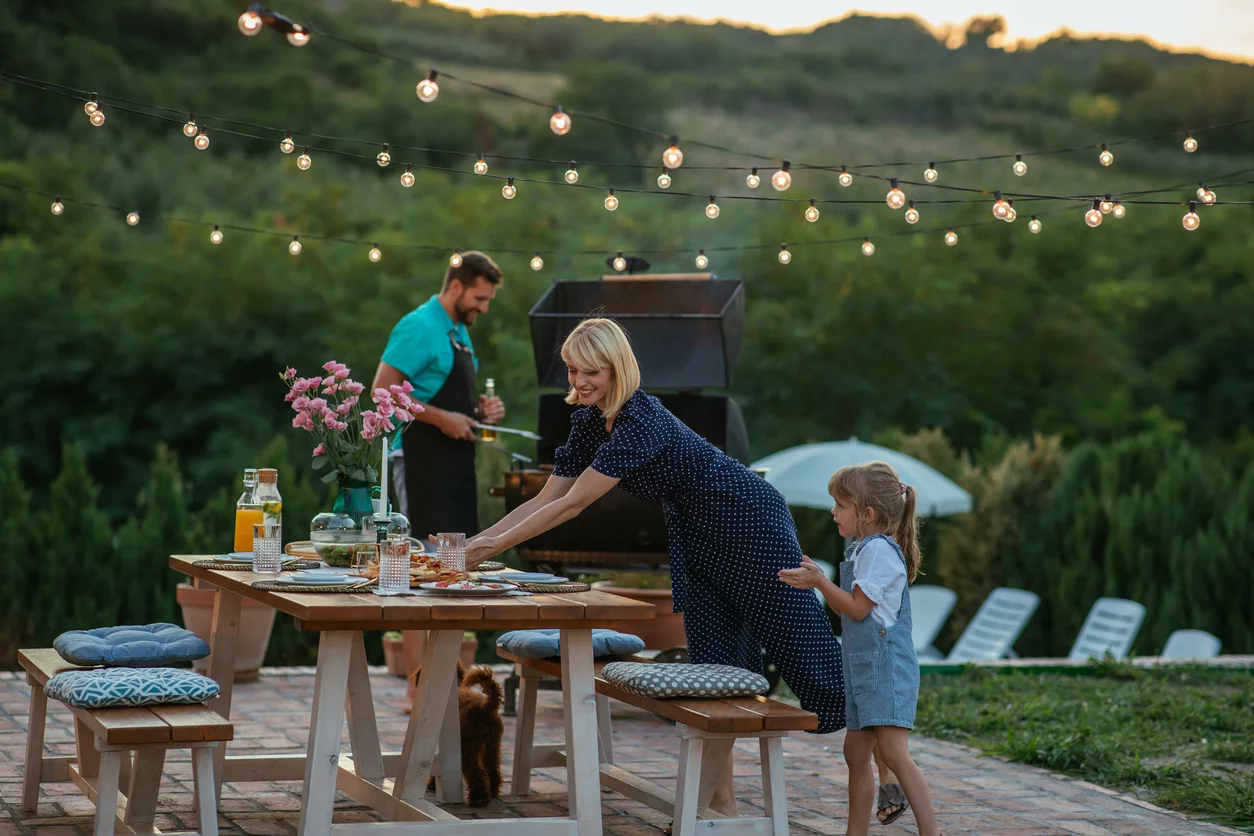 Familie bereitet einen Grillabend im Garten vor