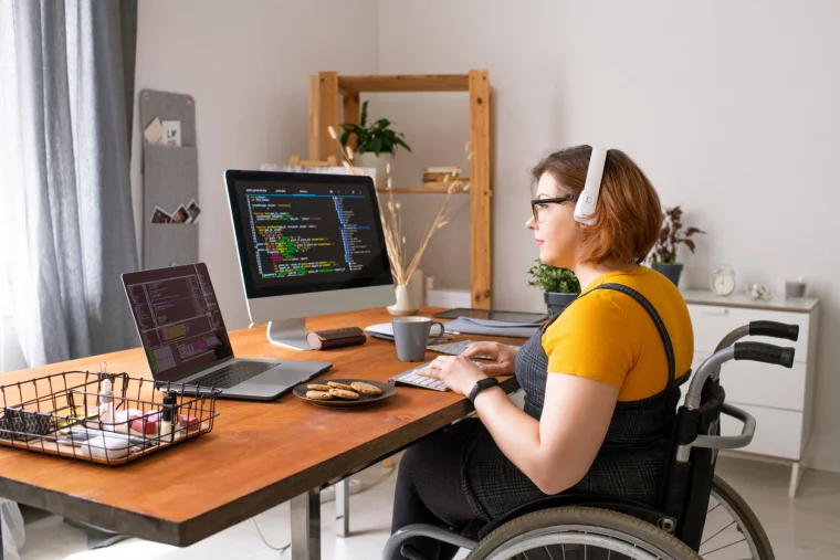 Junge behinderte Frau bei Arbeit vor dem PC