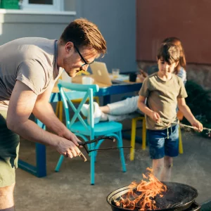 Junger Vater und Sohn grillen im Garten 