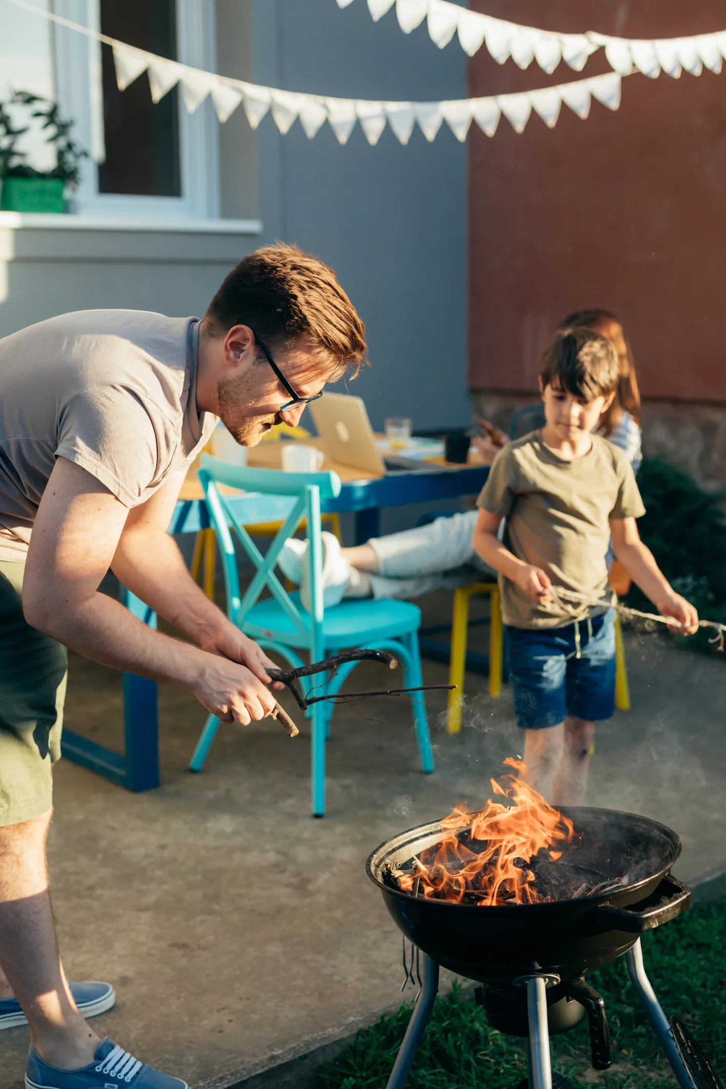 Junger Vater und Sohn grillen im Garten 