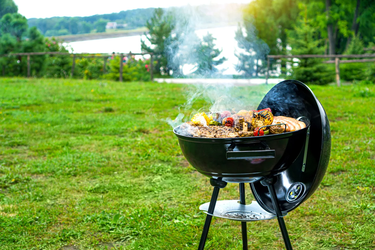 Kugelgrill im Garten voller Grillgut