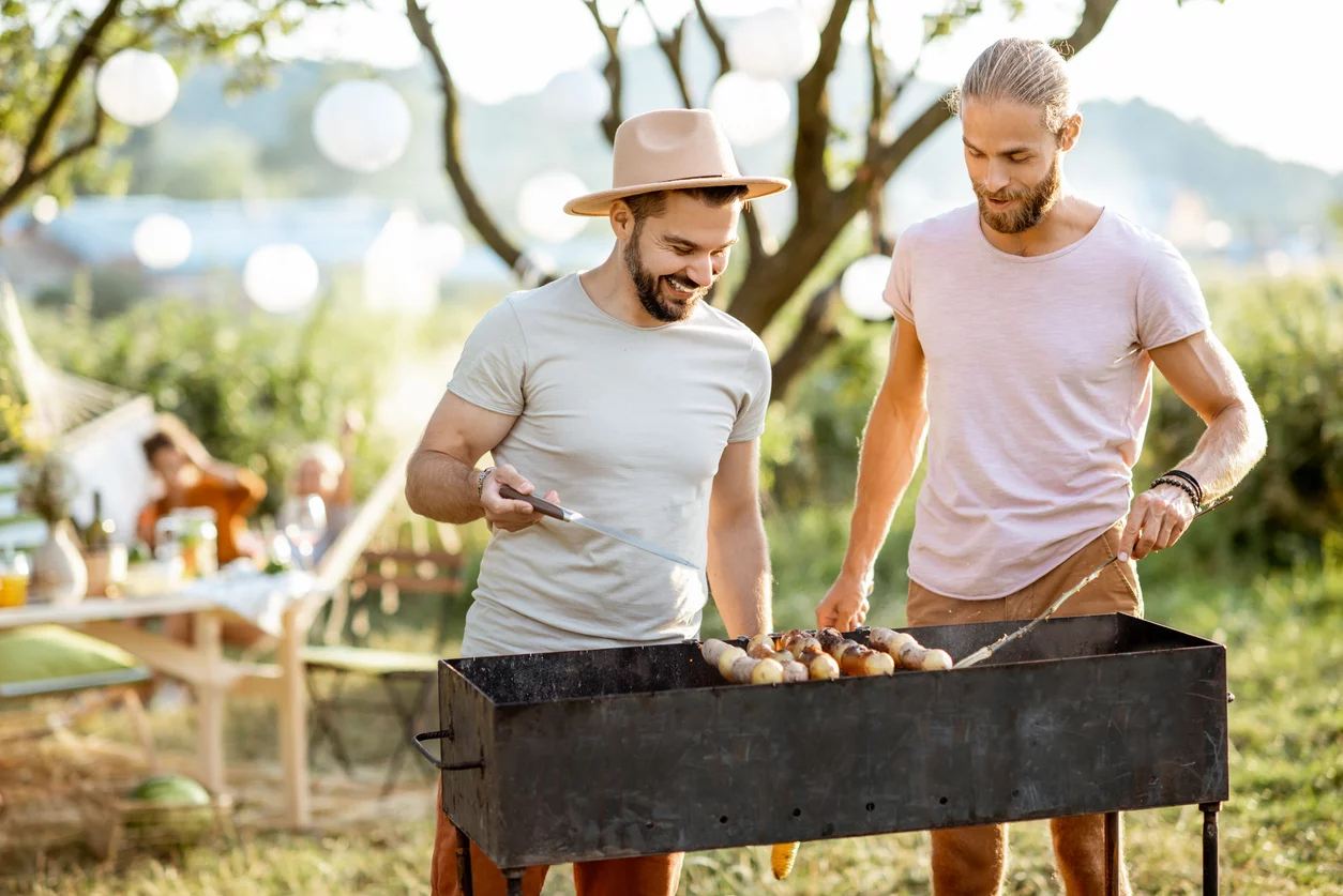 zwei Freunde grillen Pilze im Garten