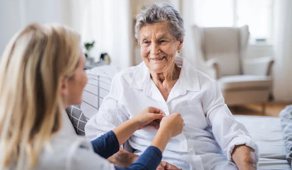 Junge Pflegerin betreut eine Seniorin - Pflege älterer Menschen