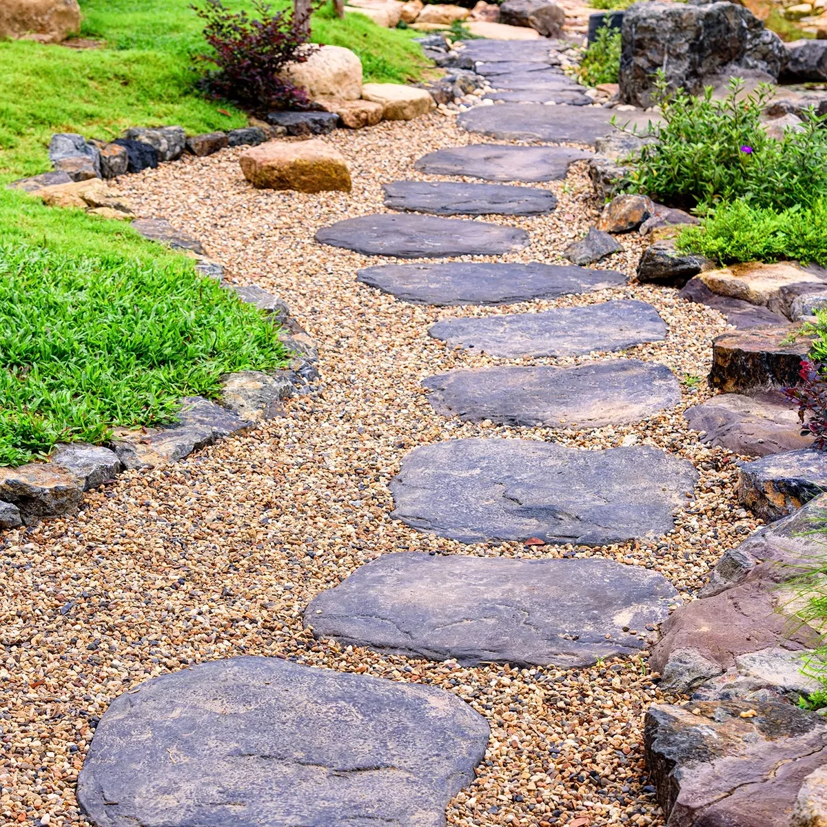große Trittsteine aus Naturstein und Kies bilden den Gartenweg aus
