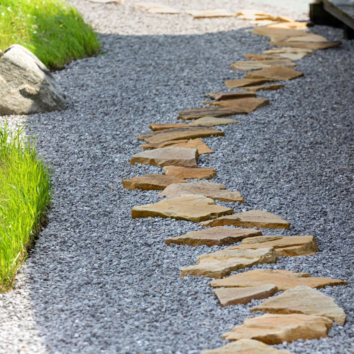 Steine in unterschiedlichen Formen und Kies auf dem Gartenweg 
