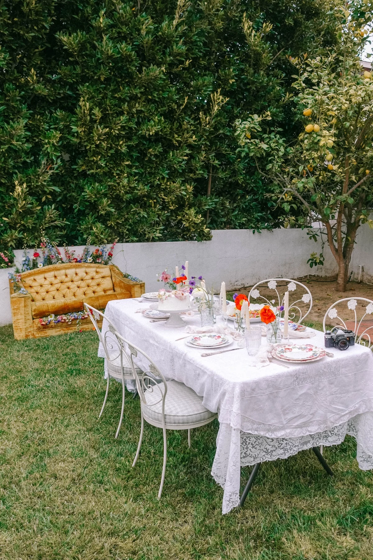 gedeckter Tisch im Garten daneben ein Vintage Sofa